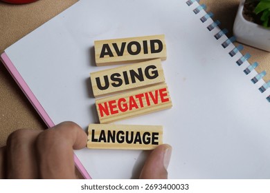 Avoid using negative language on stacked wooden cubes on the table. Business and finance concept