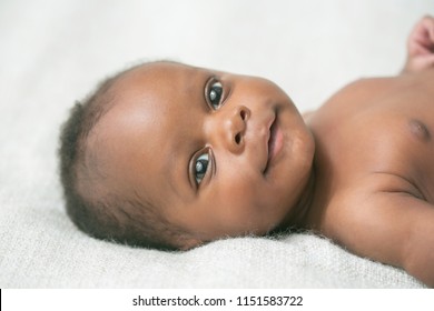 Awake Newborn Baby On Cream White Background