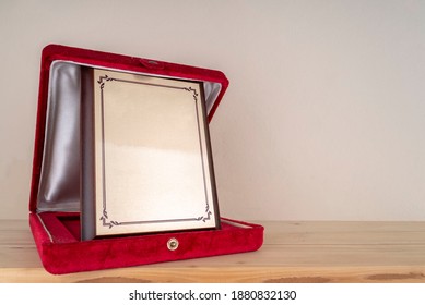 Award Plaque Standing On Wooden Shelf