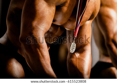 awarding of gold medal winner on man chest athlete bodybuilder