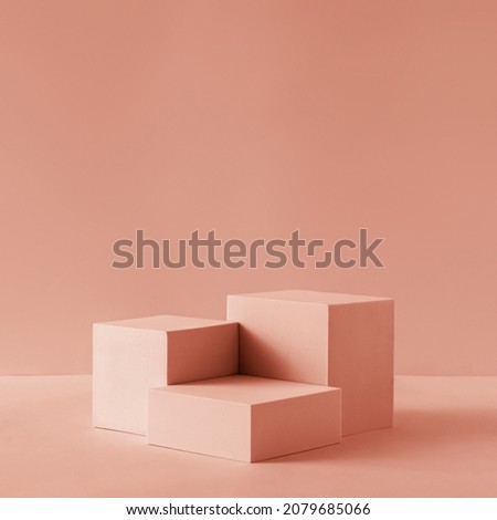 Awarding podium made of three 3d pastel square shapes of different sized against blank pink background for copy space