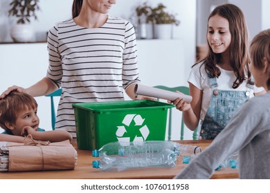 Aware Mother Teaching Smiling Children How To Recycle Household Waste