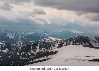 Awesome aerial view to snow mountains under cloudy sky. Scenic mountain landscape at very high altitude with cloudiness. Atmospheric mountain scenery with beautiful snowy mountain range in overcast. - Powered by Shutterstock