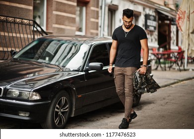 Awesome Beautiful Tall Ararbian Beard Macho Man In Glasses And Black T-shirt Walking Against Business Car.