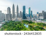 Awesome Kuala Lumpur skyline. Aerial view of a green city park in Kuala Lumpur, Malaysia. Skyscrapers are visible on blue sky background. Kuala Lumpur is a popular tourist destination of Asia.