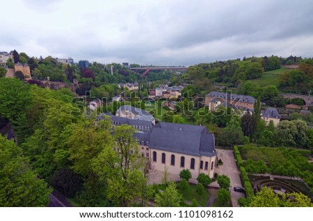 Awesome landscape view of old town Luxembourg City from top view. Grand Duchess Charlotte Bridge at the background. Spring cloudy day. Luxembourg, Grand Duchy of Luxembourg.