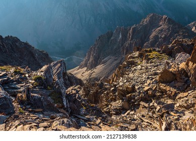 Awesome mountain view from cliff at very high altitude. Scenic landscape with beautiful sharp rocks near precipice and couloirs in sunlight. Beautiful mountain scenery on abyss edge with sharp stones.