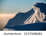 Awesome scenic view of the beautiful relief snow-covered mountain slope and freeriding skiers on it. Ski touring concept