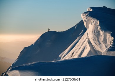 Awesome scenic view of the beautiful relief snow-covered mountain slope and freeriding skiers on it. Ski touring concept