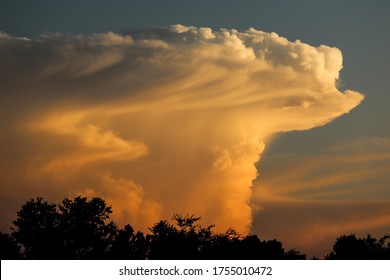 Awesome thunderhead cloud with windsheer, rainfall, and yellow sunlight