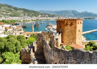 Awesome view of the Kizil Kule (Red Tower) from fortress walls of Alanya Castle in Turkey. The Mediterranean Sea is visible in background. The octagonal red brick tower is a popular tourist attraction - Powered by Shutterstock