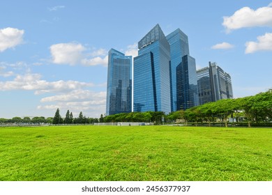 Awesome view of skyscrapers at downtown across green lawn in Singapore. High-rise buildings are visible on blue sky background. Singapore skyline. Singapore is a popular tourist destination of Asia. - Powered by Shutterstock