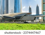 Awesome view of train of the Dubai Metro arriving to Financial Centre Station at downtown of Dubai, United Arab Emirates (UAE). Amazing skyscrapers are visible on blue sky background. Scenic cityscape