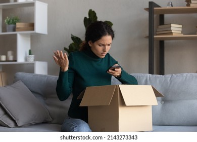 Awful service. Angry latin female shopper hold opened box call delivery company to complain on getting wrong order. Young lady client writing feedback on shop website dissatisfied with product quality