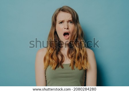 Its awful. Young displeased woman with slightly wavy hair looking at camera with dissatisfied shocked face expression and open mouth, unhappy female seeing something ugly and terrible in front of her Stock photo © 
