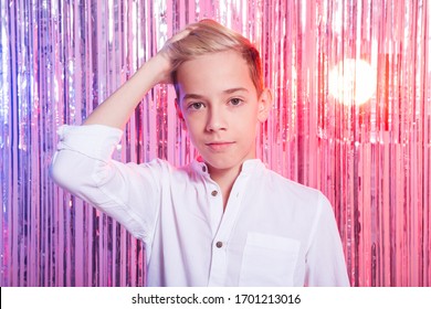 Awkward Age And Teenage Concept - Portrait Of Teen Boy At A Party. Shiny Background.