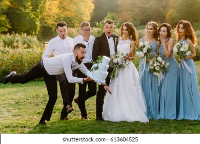 Awkward friend of the groom throws a wedding cake. It falls to the ground in everybody's sight. Friends are in shock. The bearded friend of the groom drops the wedding cake