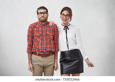 Awkward Male Geek Being Reserved, Feels Puzzled And Shy As Has First Date With Girlfriend, Doesn`t Know How To Behave. Worried Nervous Male Wonk Stands Near Beautiful Female With Pleasant Smile