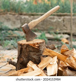 Ax and firewood in the yard. Ax in the stump. Pile of firewood and tree stump. Firewood for the winter. - Powered by Shutterstock