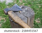 an ax with a wooden handle lies on a wooden chopping block. High quality photo