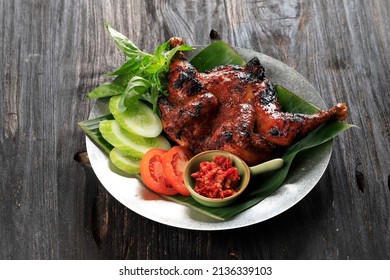 Ayam Bakar Bakakak or Whole Roasted Chicken with Sweet Soy Sauce, Served with Sliced Cucumber, Tomato, and Basil Leaf. Indonesian Popular Dish Poultry Recipe