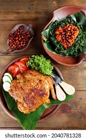 Ayam bakar Taliwang  is a traditional roast chicken from Lombok Indonesia on a wooden background, served with plecing.