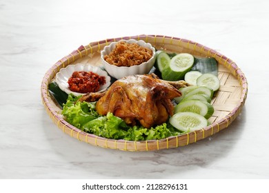 Ayam Goreng Bakakak or Whole Fried  Chicken, Served with Sambal and Serundeng, on White Table