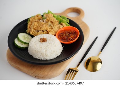 Ayam Goreng Geprek or Pecel Ayam Sambal Bawang is a Indonesian fried chicken with Tofu and Tempeh any fresh vegetable and smashed with spicy sambal. Daily asian food. On white background.