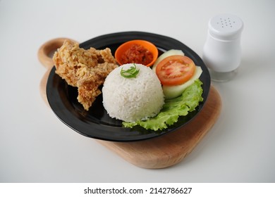 Ayam Goreng Lamongan or Pecel Ayam or Ayam Penyet is a Indonesian fried chicken with Tofu and Tempeh any fresh vegetable and chili sauce or spicy sambal. Daily asian food. On white background.