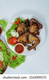 Ayam Goreng Lengkuas or Pecel Ayam or Ayam Penyet is a traditional Indonesian fried chicken with fresh vegetable and chili sauce, served in plate on white background