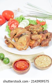 Ayam Goreng Lengkuas or Pecel Ayam or Ayam Penyet is a traditional Indonesian fried chicken with fresh vegetable and chili sauce, served in plate on white background