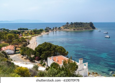 AYDIN, TURKEY - APRIL 30, 2016 : Seascape view of coastline with blue bright sea with small trees and sandy beach on blue sky background.