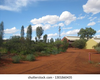 Ayers Rock Resort, Northern Territory, Australia 02/21/18. Red Dirt And Green Shrubs Around The Resort.