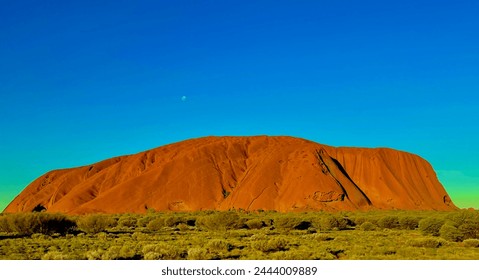 Ayers Rock (Uluru) nearing sunset with a full moon above. - Powered by Shutterstock