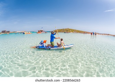 Ayia Napa, Cyprus - April 04, 2018: Father And Kids Paddleboarding On SUP At Nissi Beach