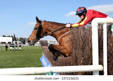 AYR RACECOURSE, AYRSHIRE, SCOTLAND, UK : 13 APRIL 2019 : Racehorse Cogry Ridden By Sam Twiston-Davies Jumps The Last Fence Of The Scottish Grand National, Watched By A Group Of Jockeys On The Far Side