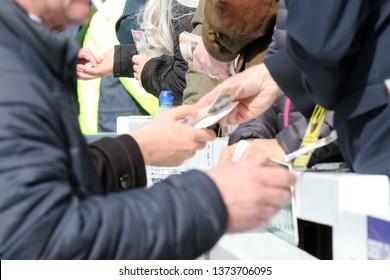 AYR RACECOURSE, AYRSHIRE, SCOTLAND, UK : 12 APRIL 2019 : Money Changes Hands Between The Racegoers And Bookmakers On Course At The Scottish Grand National Meeting At Ayr