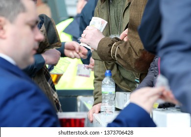 AYR RACECOURSE, AYRSHIRE, SCOTLAND, UK : 12 APRIL 2019 : Money Changes Hands Between The Racegoers And Bookmakers On Course At The Scottish Grand National Meeting At Ayr