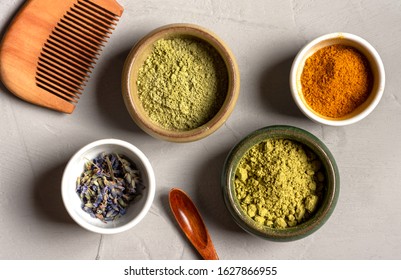 Ayurvedic Hair Care Products. Henna, Turmeric And Neem Powder In Bowls On A Grey Background, Top View. Natural Care And Hair Coloring.