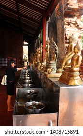 Ayutthaya, Thailand - April 29, 2014. Woman In The Buddhist Temple Lights A Lighter As An Offering To Buddha.