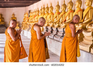 Ayutthaya, Thailand - March, 12, 2017 : Monks praying at walkway Golnden Buddha statue in Wat Puttaisawan temple, Ayutthaya, Thailand