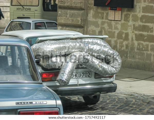 Azerbaijan, Baku - April 30, 2007: Classic\
soviet vintage sedan car LADA VAZ 2107 with trunk that is overload\
by construction\
materials.