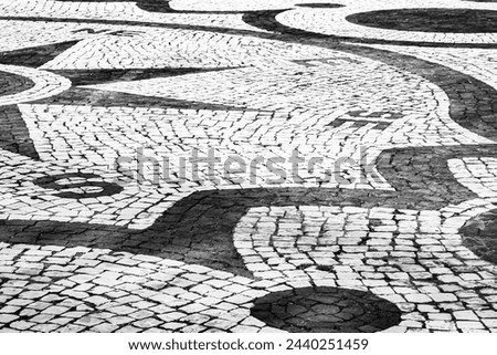 Azores, Nordeste town square, small cobblestone streetscape. Black and white image, landscape, the mosaic depicts a compass.