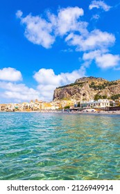 Azure water of Mediterranean sea at Cefalu beach, Cefalu town, Sicily, Italy. One of the best beach on Sicily. Mount La Rocca di Cefalu on background - Shutterstock ID 2126949914