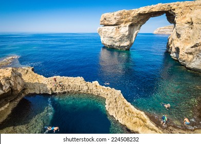 The Azure Window in Gozo island - Mediterranean nature wonder in beautiful Malta - Unrecognizable touristic scuba divers - World famous rock formation landmark collapsed after sea storm - Powered by Shutterstock