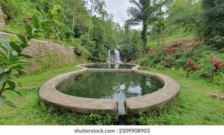 The Babak Pelangi Waterfall tourist attraction has a swimming pool in front of the waterfall - Powered by Shutterstock