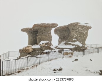 Babele (the Old Ladies) stone group, a natural rock formation in the Bucegi Natural Park, in the Bucegi Mountains of Romania, during a blizzard on a winter day. - Shutterstock ID 2233757893