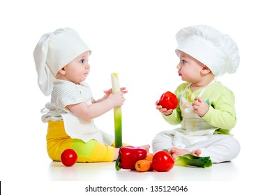 babies boy and girl wearing a chef hat with healthy  food vegetables