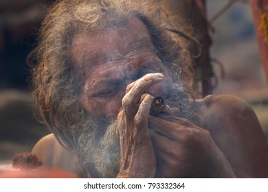 BABUGHAT, KOLKATA, WEST BENGAL / INDIA - 11TH JANUARY 2015 : Hindu Sadhu smoking marijuana, locally called Ganja, a form of canabis sativa . - Shutterstock ID 793332364