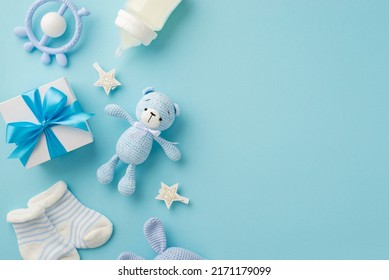 Baby accessories concept. Top view photo of giftbox teether knitted bunny rattle toy socks milk bottle and stars on isolated pastel blue background with empty space - Powered by Shutterstock